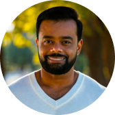 Man in a white sweater outdoors.